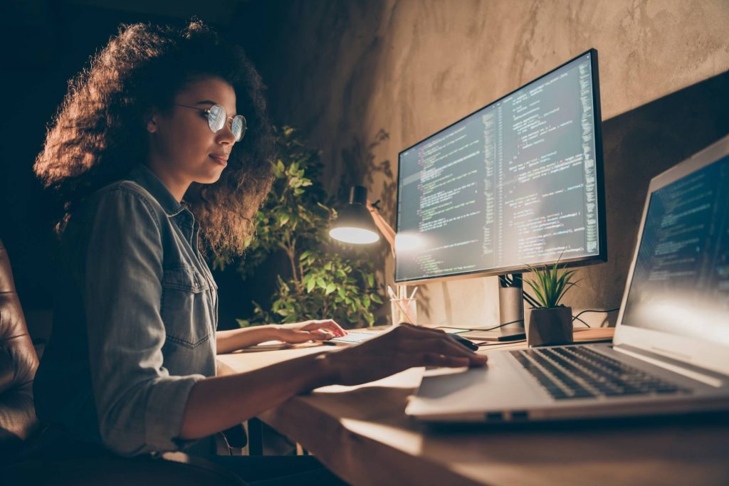 African american woman working on laptop and coding