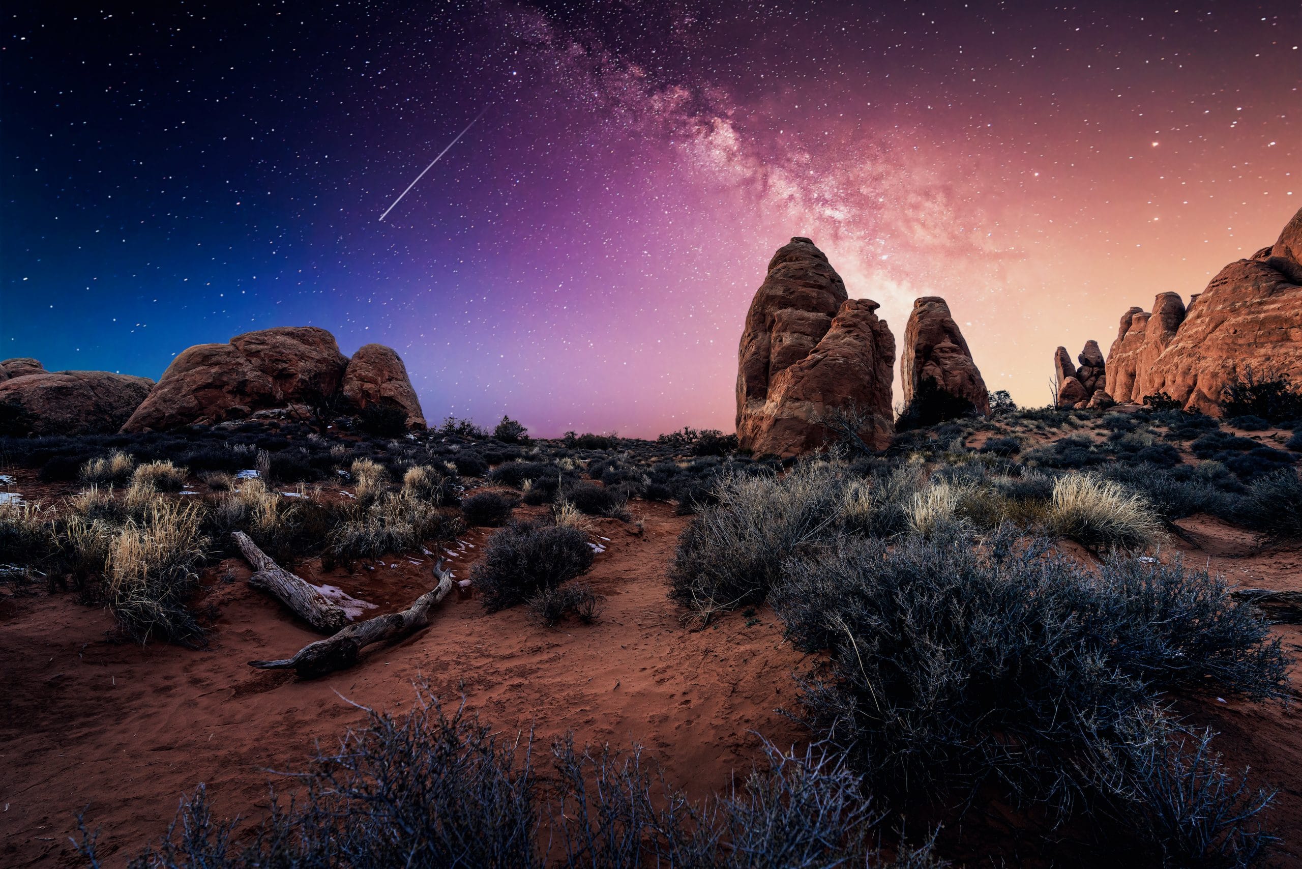 Shooting star at night with rock formations