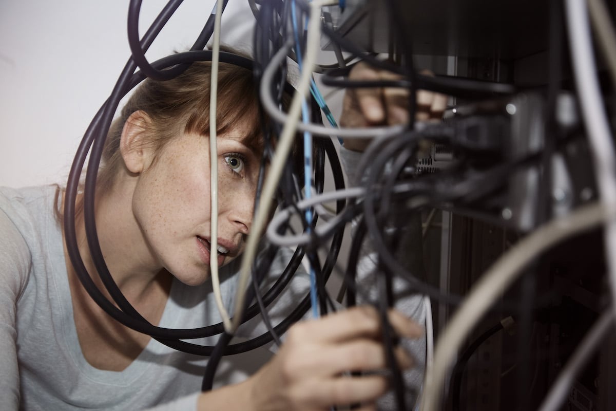 Woman looking at tangled cables