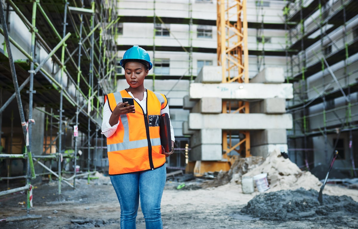Construction worker on phone utilizing IT solutions