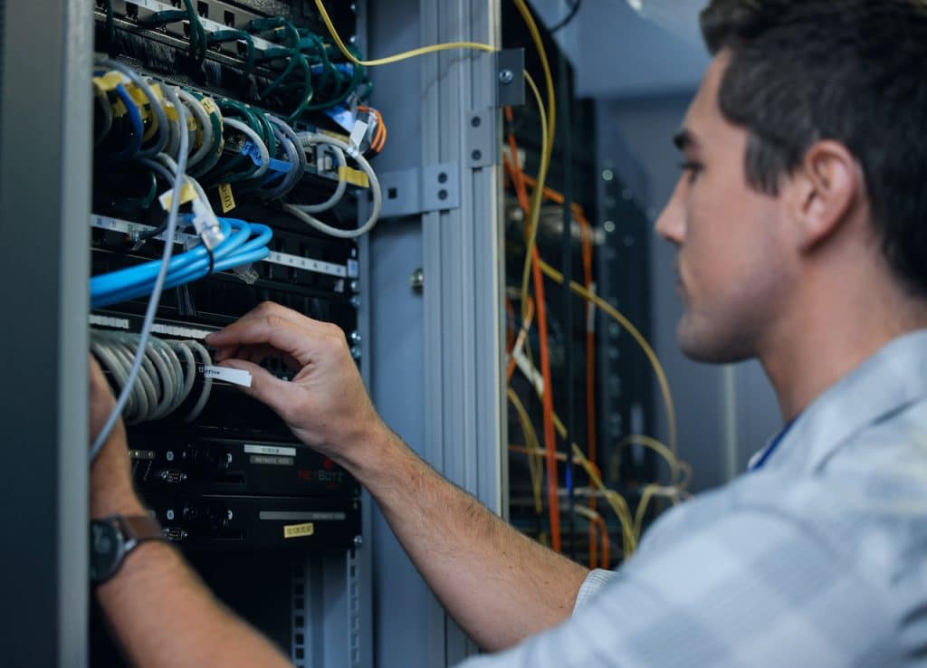 outsourced technical support technician working in server room