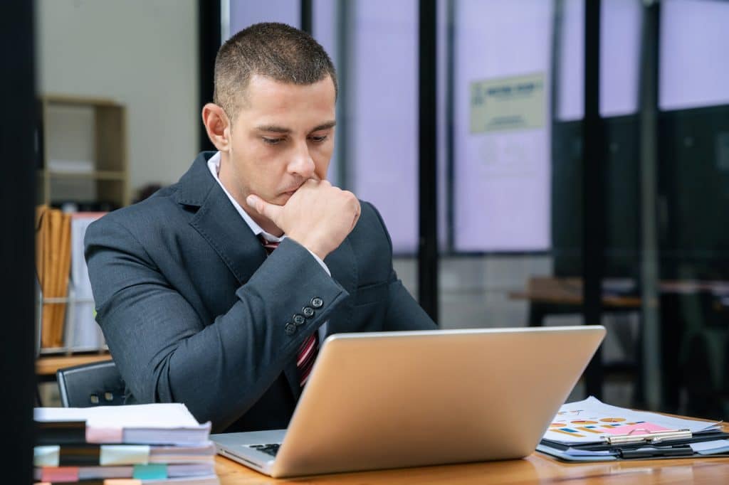 man at desk researching outsourced tech support companies