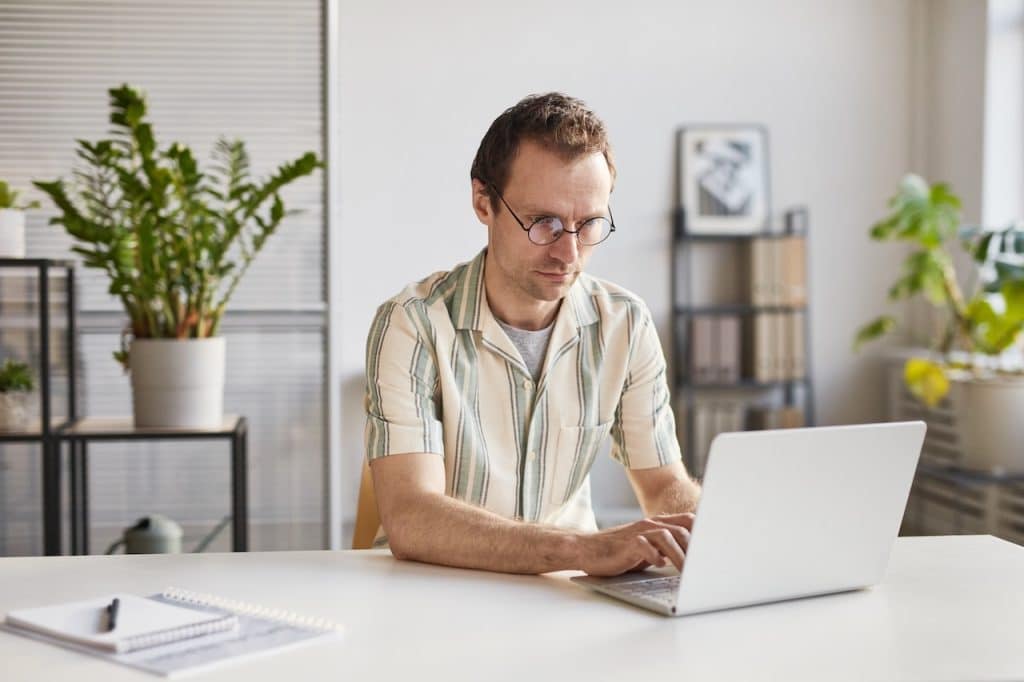 man working on computer avoiding phishing attempts while looking through emails