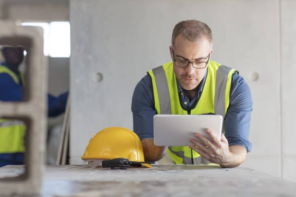 construction worker on tablet using construction it support while at job site