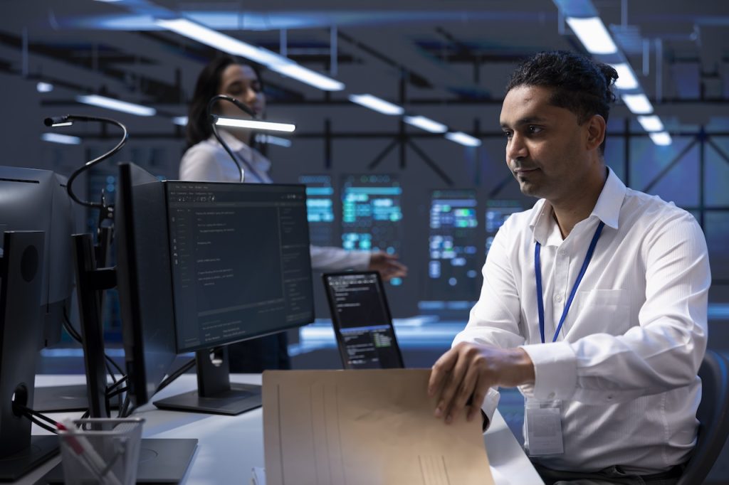 computer security service worker on computer in server room