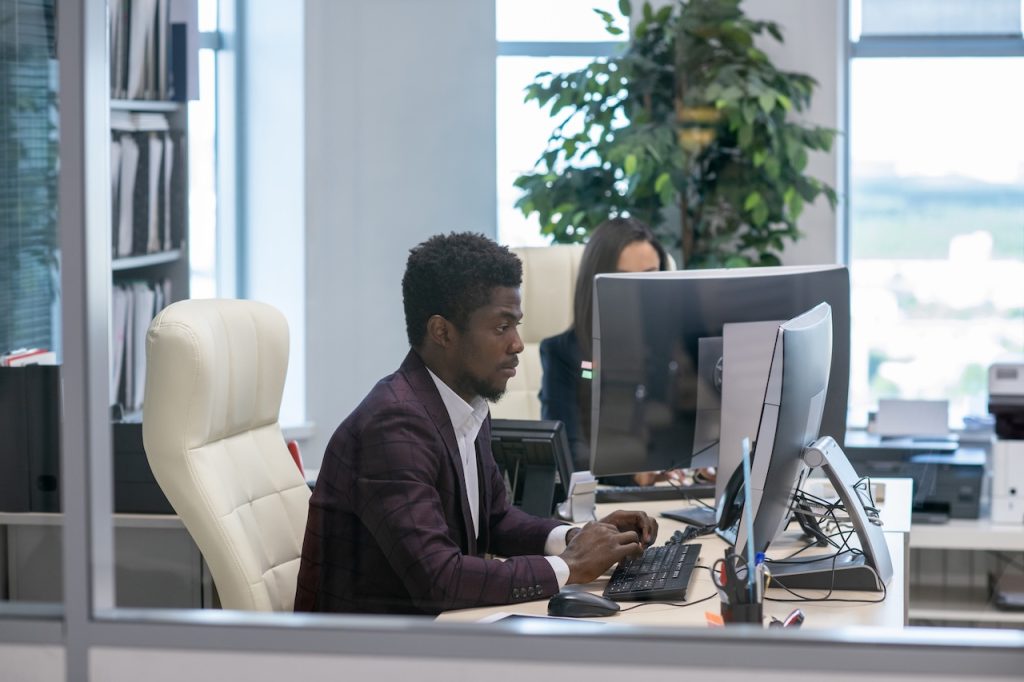 coworkers in office using remote device management services on computers