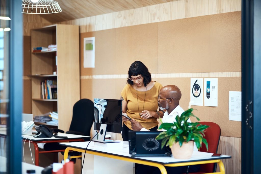 coworkers in office on computer comparing it consulting services