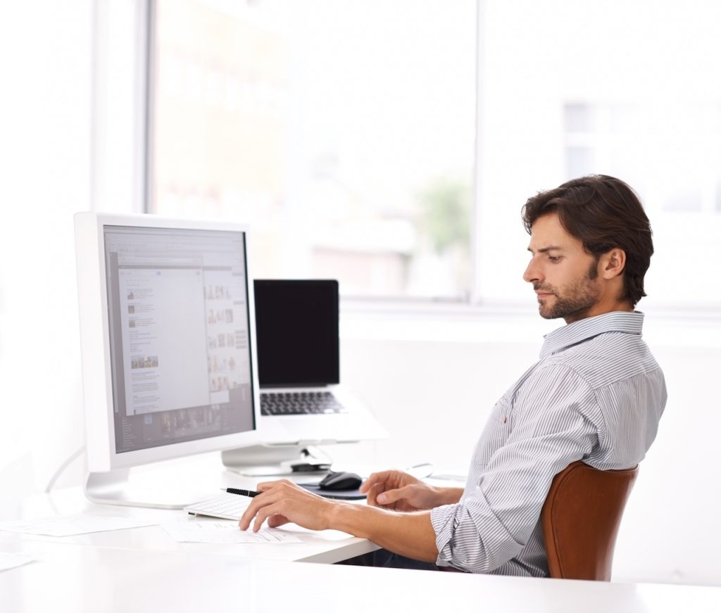 man working in office on computer using information technology consulting services