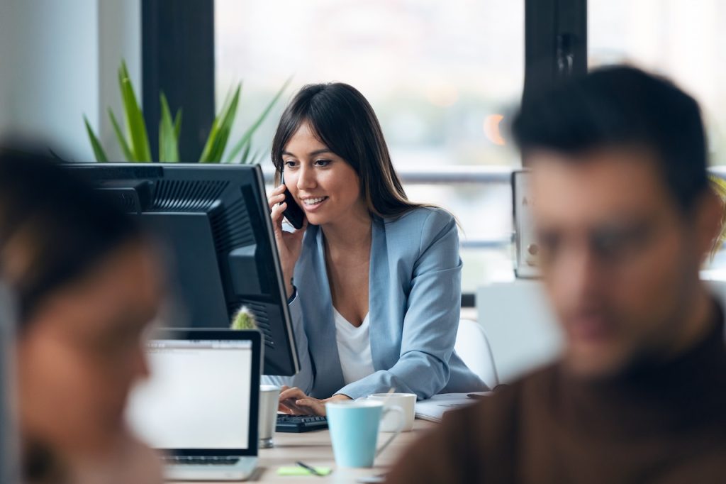 woman at work on phone using voip features from mobile device