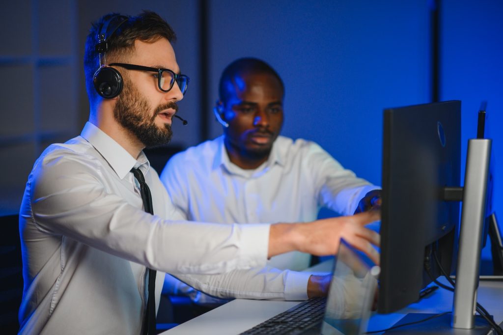 coworkers evaluating security systems on computer at business