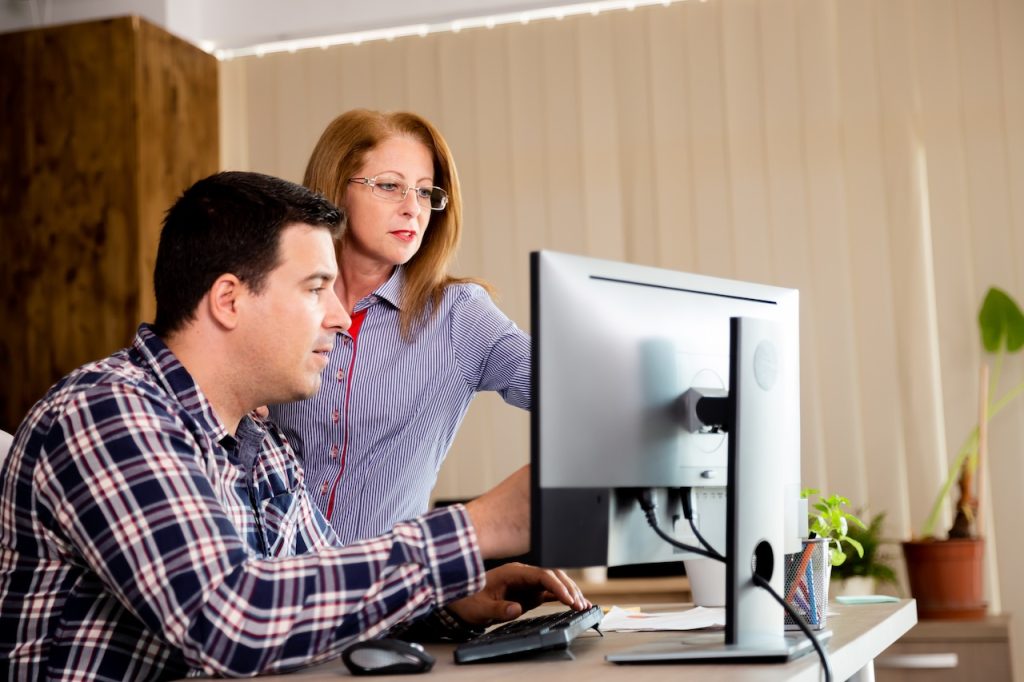 coworkers working on computer in office