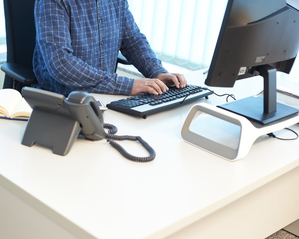 man typing on a computer at an office desk