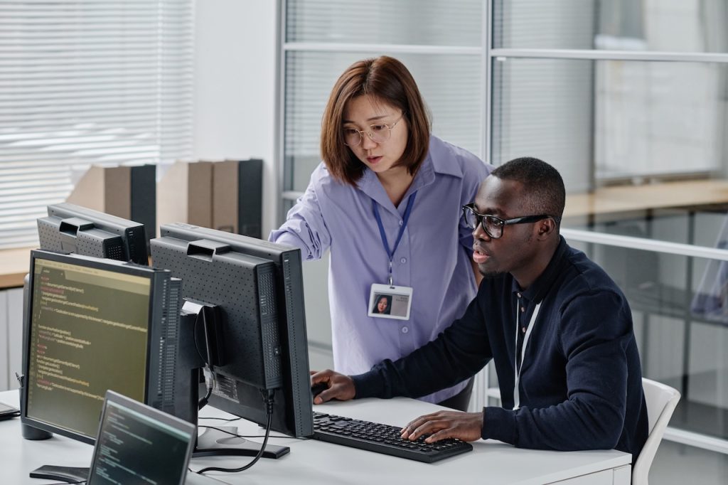 male and female coworkers working on computer together