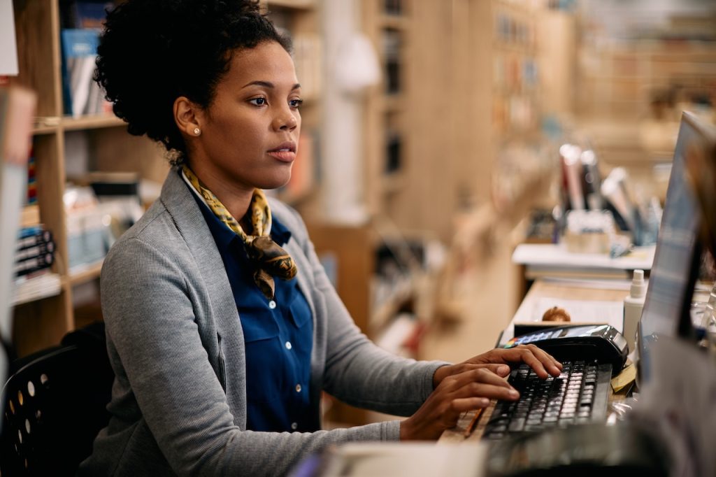 woman working on computer in store using it services for retail