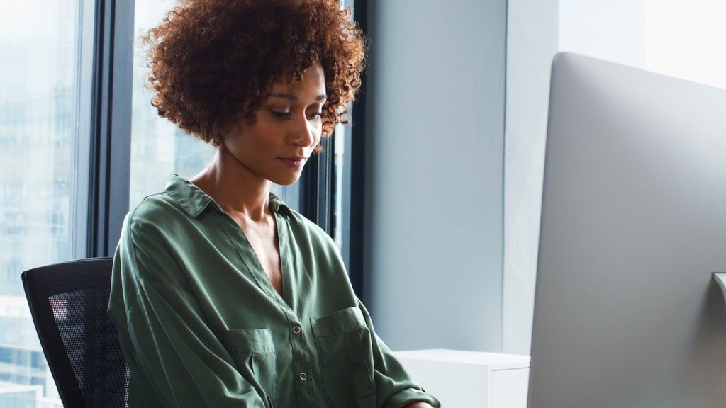 female therapist securely adding notes on her computer using IT for therapists