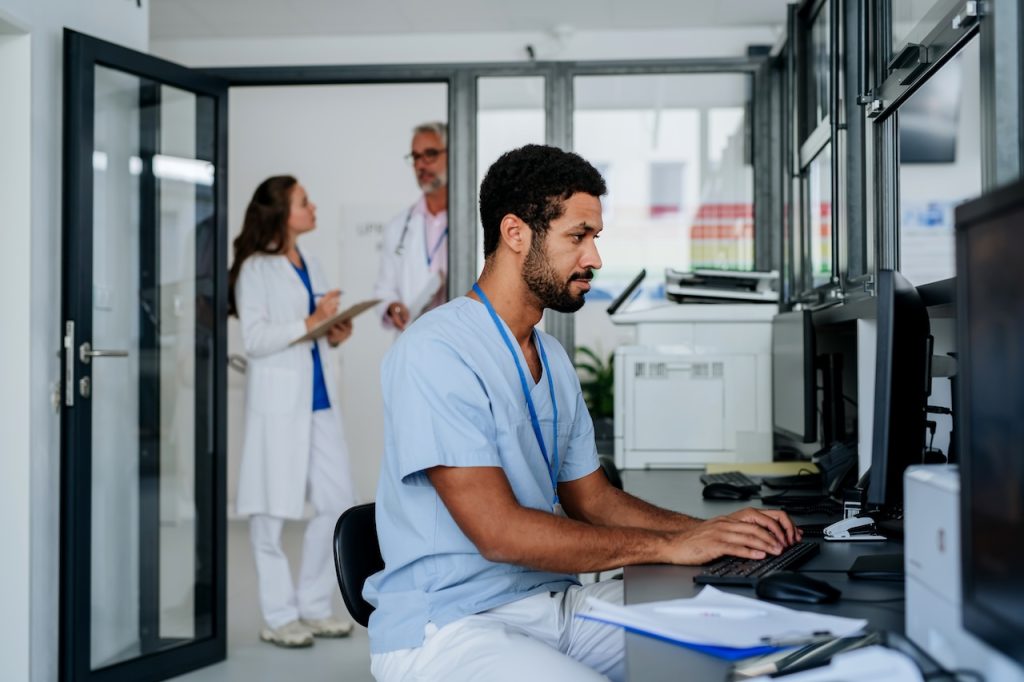 Young doctor working on computer in the hospital office